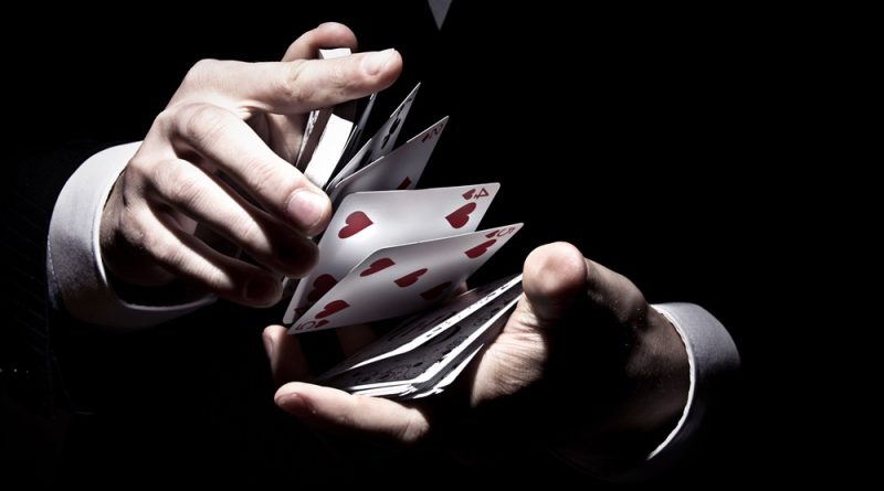 magician shuffling the cards in a cool way under the spotlight