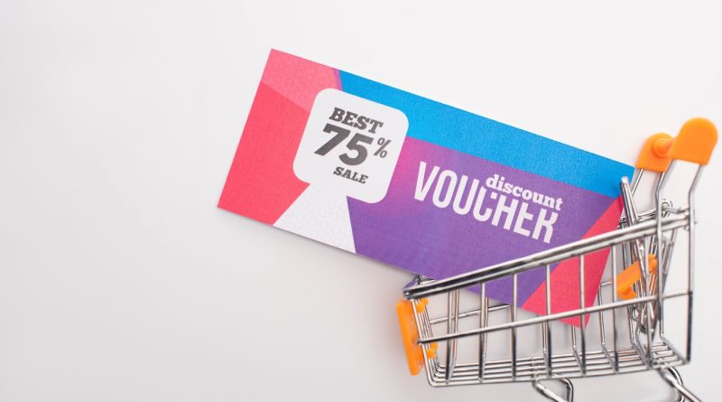 top view of discount voucher in toy shopping cart on white background